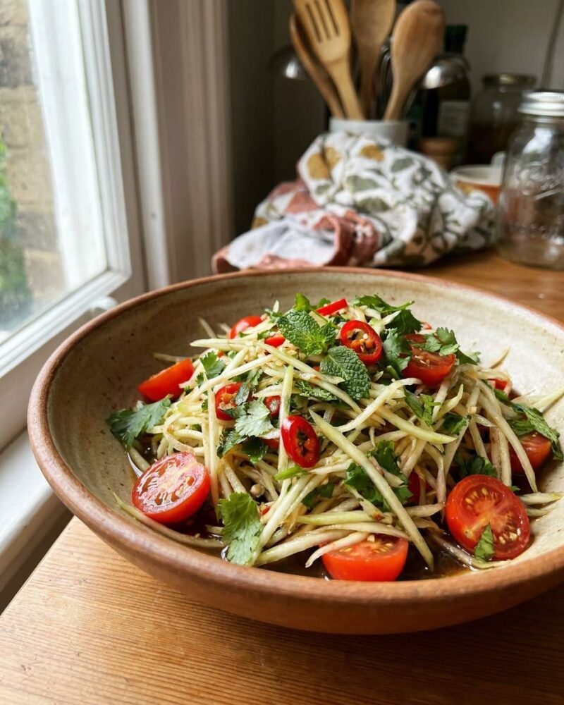 Fresh green papaya salad with cherry tomatoes and herbs